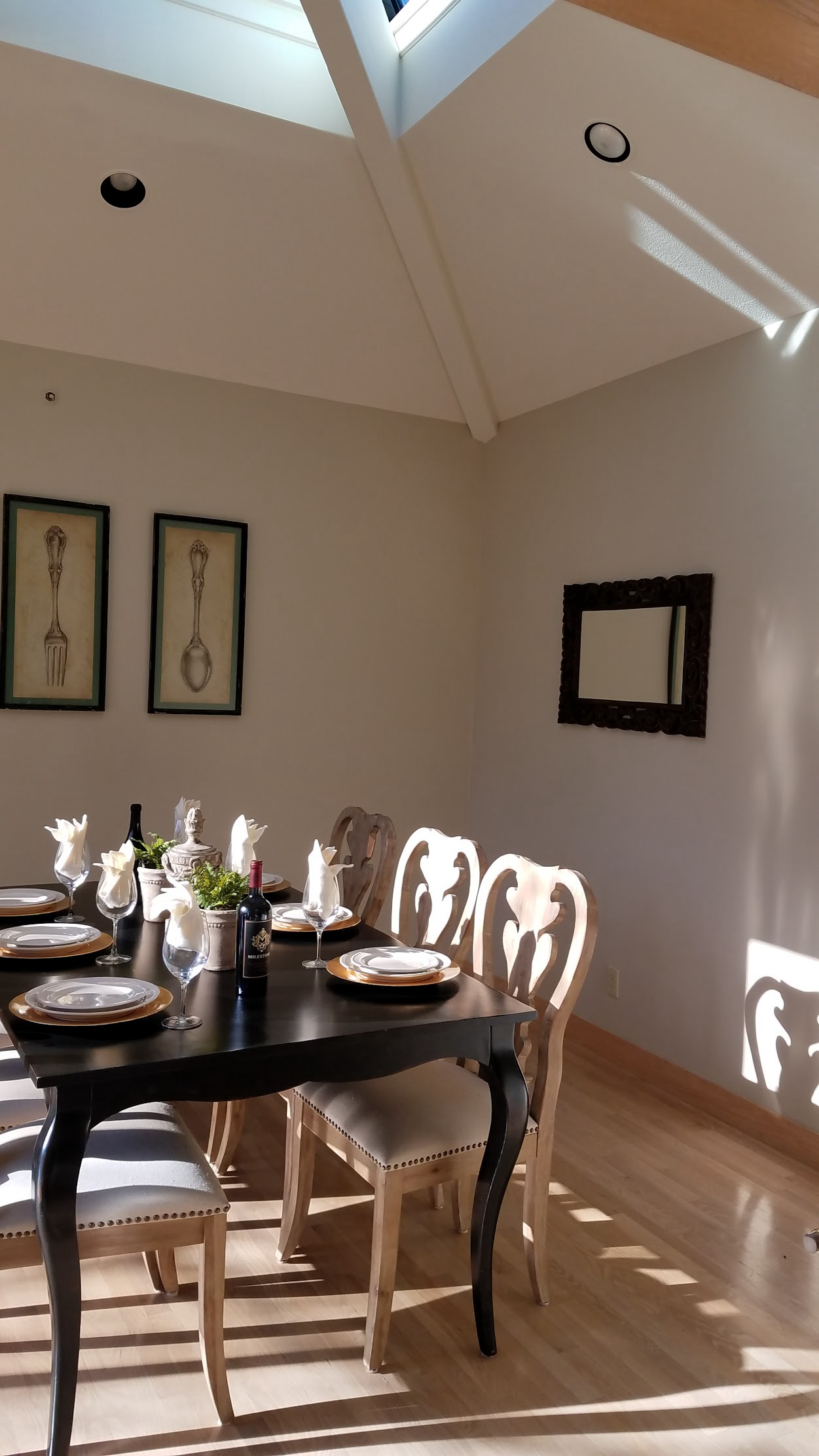 Bright dining room with freshly painted vaulted ceiling and warm neutral walls filled with natural light